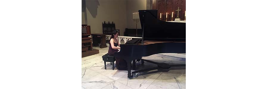 Image of a woman sitting and playing a piano