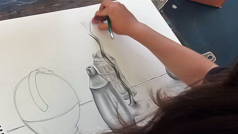 student working on graphite drawing