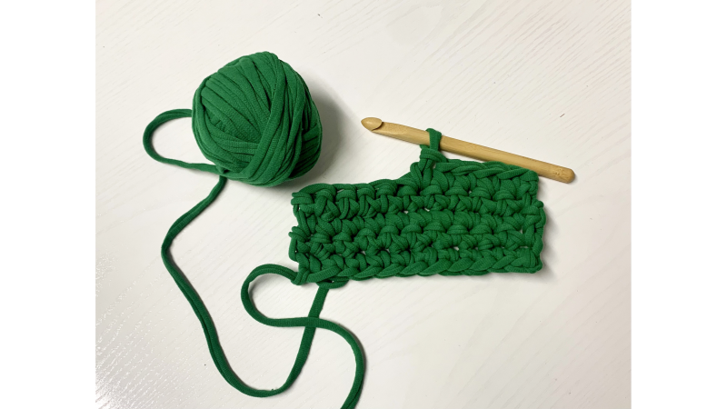 ball of green t-shirt yarn with crochet hook